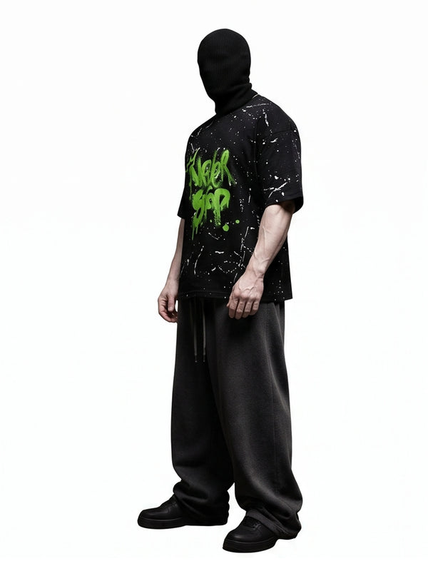 "NEVER STOP" Oversized Streetwear T-Shirt – All-Over Splatter Print (Black)